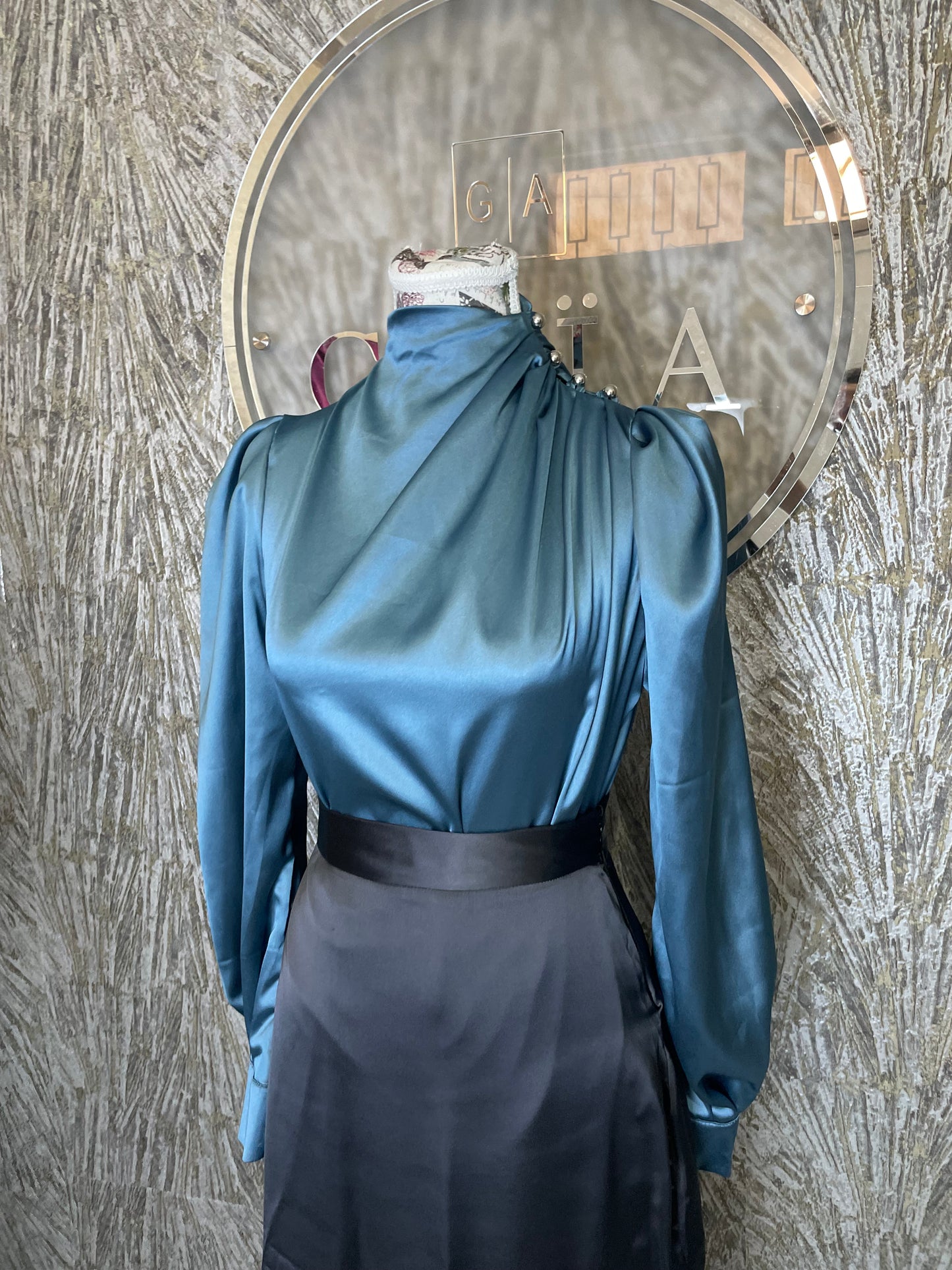Chemise satinée bleu pétrole – Col montant drapé & boutons bijoux